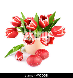 Bouquet de tulipes rouges stripy et deux œufs de Pâques colorés rouge isolé sur fond blanc, l'espace de texte Banque D'Images