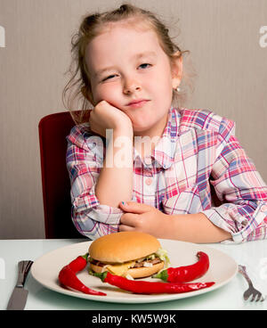 Petite fille émotionnellement mange un sandwich Banque D'Images