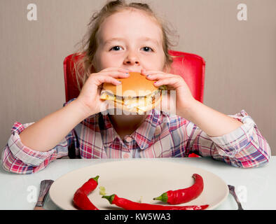 Petite fille émotionnellement mange un sandwich Banque D'Images