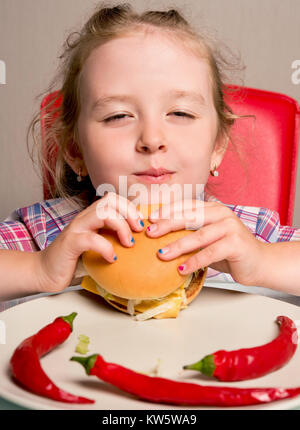 Petite fille émotionnellement mange un sandwich Banque D'Images