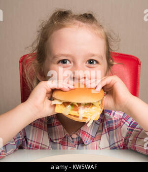 Petite fille émotionnellement mange un sandwich Banque D'Images