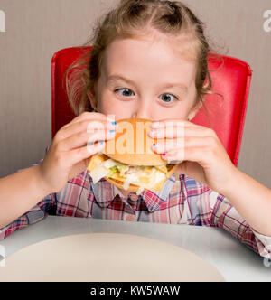 Petite fille émotionnellement mange un sandwich Banque D'Images