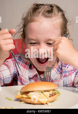 Petite fille émotionnellement mange un sandwich Banque D'Images