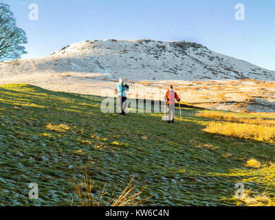 L'homme et la femme marche dans la neige au pied d'Shutlingsloe Hill and Wildboarclough Peak District le 3e plus haut sommet dans Cheshire Banque D'Images