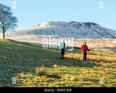 L'homme et la femme marche dans la neige au pied d'Shutlingsloe Hill and Wildboarclough Peak District le 3e plus haut sommet dans Cheshire Banque D'Images