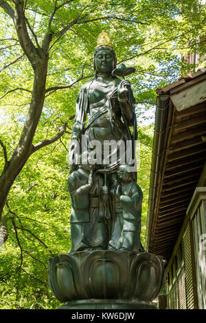 - Kanazawa au Japon, le 11 juin 2017 : Hakuju Kanzenon Bodhisattva statue avec un vieux couple au pied de la déité bouddhiste en face de l'Hase-san Kann Banque D'Images