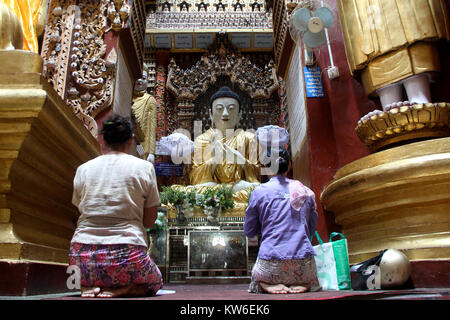 Femmes près de Bouddha de Temple, Mohnyin Thambuddhei Paya, Moniwa, Myanmar Banque D'Images
