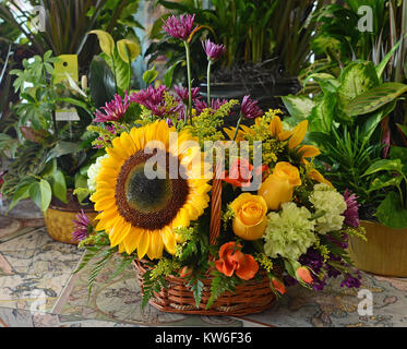 Panier d'un pays débordant de tournesols, roses et autres fleurs du jardin. Banque D'Images