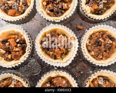 Faire de petits pâtés : mince pies dans une plaque de cuisson pour les cercles de pâte ont été poussées dans le moule et rempli de viande hachée. Close up. 13 de 16 Banque D'Images