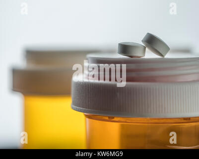 Deux pilules blanches sur un bateau de médicaments de plastique couleur ambre, conceptual image Banque D'Images