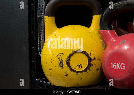 Jeu de colorful usé kettlebells sur une étagère métallique dans une salle de sport. Banque D'Images