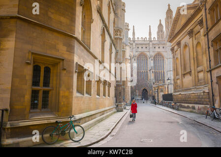 Cambridge étudiant UK, vue d'une étudiante universitaire de sexe féminin portant un manteau rouge marchant le long de Trinity Lane dans le centre de Cambridge, Angleterre, Royaume-Uni Banque D'Images