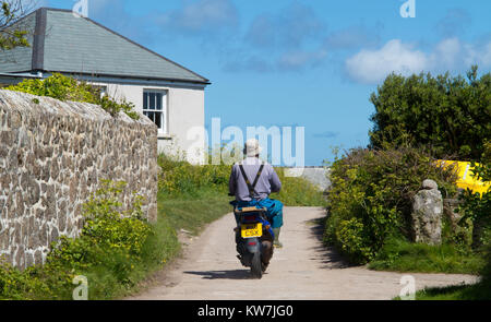 L'homme monte un Scooter bas an english Country Lane Banque D'Images