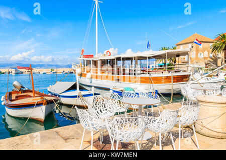 Les bateaux de pêche et des chaises de bar café local à Sutivan, port, île de Brac, Croatie Banque D'Images