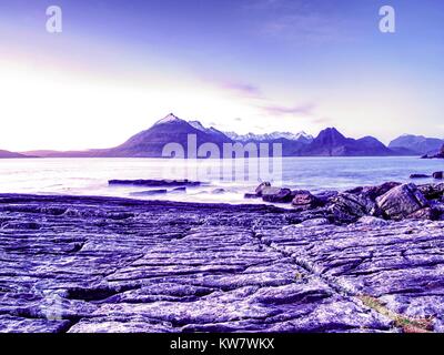 Des rochers près de Elgol, Loch Scavaig, île de Skye en Écosse. Coucher du soleil chaud froid en couleurs soirée. Février Les photographes populaire destination. Banque D'Images