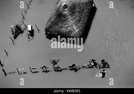 Inondations au Mozambique Mars 2000 ; une famille à la périphérie de Xai Xai, toujours profondément dans l'eau et se laver leurs vêtements. Banque D'Images