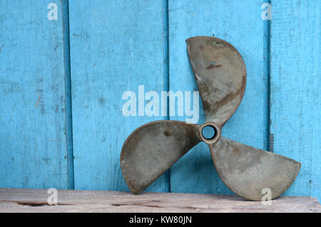Les Hélices de navires vieux métal bleu sur mur en bois Banque D'Images