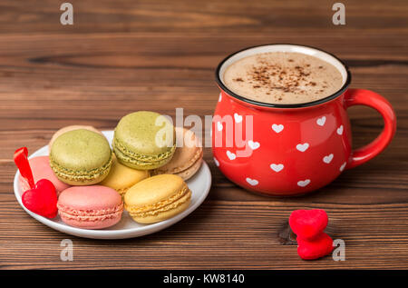 Colorful macarons cake se trouvent sur assiette, tasse de café, décoré coeurs rouges, St Valentines Day concept Banque D'Images