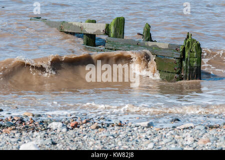 La marée et les vagues ayant leur énergie dissipée par le brise-lames en bois sur la plage de sable et de galets à la station balnéaire de Cleveleys Banque D'Images