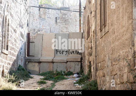 Hébron, en Palestine, le 7 novembre 2010. Pardon graffitis sur un béton et barbelés barier installé entre zone occupée par Israël et Palestiniens Banque D'Images