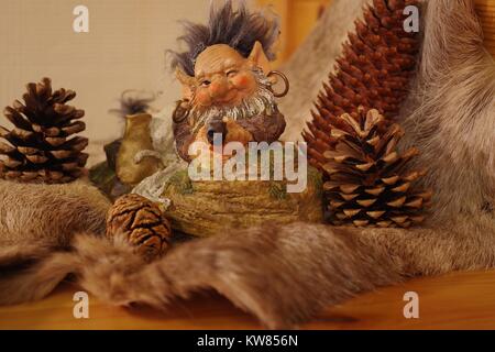 La Laponie finlandaise ou modèle de Troll Gnome à la chasse avec arme à feu sur une peau de renne entouré de cocottes. L'hiver 2017. Banque D'Images