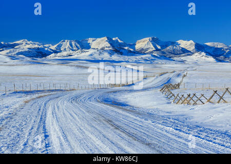 Route menant au front des montagnes Rocheuses en hiver près de augusta, Montana Banque D'Images