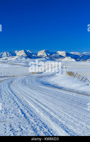 Route menant au front des montagnes Rocheuses en hiver près de augusta, Montana Banque D'Images