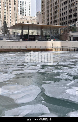 Chicago, USA. 31 décembre 2017. Des panneaux de mise en garde les passants par des chutes de glace sont à l'écran autour de la nouvelle figure de proue des Apple Store, North Michigan Avenue, à côté de la rivière Chicago. Le bâtiment, conçu par les architectes britanniques Foster +Partners, possède un toit en forme le couvercle d'un portable Apple et s'affiche à l'absence visible des gouttières. Les glaçons qui se sont formées dans l'actuelle des températures sous zéro se sont écrasés au sol ci-dessous mettant en danger le public et le magasin est actuellement confronté à des critiques de la part des sections locales à élaborer une solution. Crédit : Stephen Chung / Alamy Live News Banque D'Images