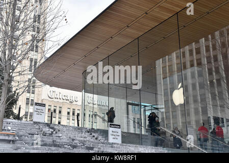 Chicago, USA. 31 décembre 2017. Des panneaux de mise en garde les passants par des chutes de glace sont à l'écran autour de la nouvelle figure de proue des Apple Store, North Michigan Avenue, à côté de la rivière Chicago. Le bâtiment, conçu par les architectes britanniques Foster +Partners, possède un toit en forme le couvercle d'un portable Apple et s'affiche à l'absence visible des gouttières. Les glaçons qui se sont formées dans l'actuelle des températures sous zéro se sont écrasés au sol ci-dessous mettant en danger le public et le magasin est actuellement confronté à des critiques de la part des sections locales à élaborer une solution. Crédit : Stephen Chung / Alamy Live News Banque D'Images