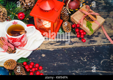 Tasse rouge de teaa avec le citron, les lumières de Noël et de décoration sur fond rustique avec copyspace Banque D'Images