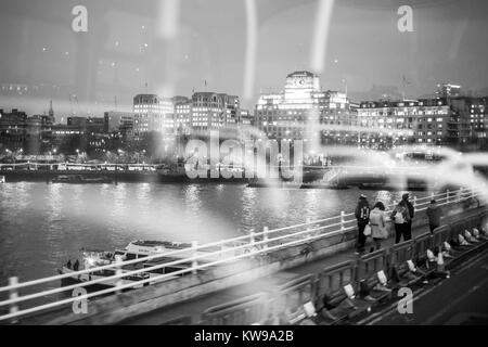 Vue de la rive nord de la Tamise à Londres, en traversant le pont de Waterloo, avec la réflexion de l'intérieur de l'autobus visible. Banque D'Images