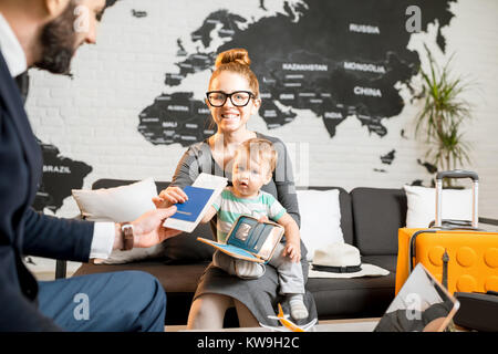 Happy Family sitting avec l'homme agent au bureau de l'agence de voyage avec de belles carte sur l'arrière-plan la réception des billets et des passeports pour un été vacat Banque D'Images