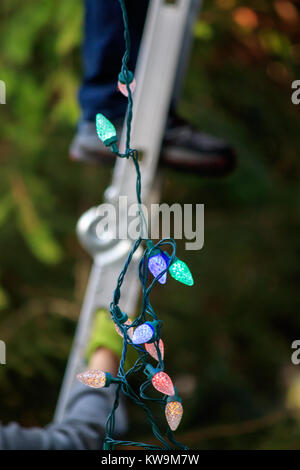 Pieds de l'homme sur l'échelle de bain mains tiennent de décoration Banque D'Images