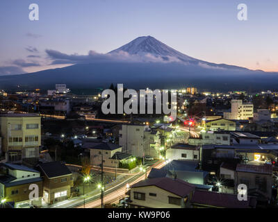 Une longue exposition de Mont Fuji pris dans une ville près du lac Kawaguchiko avec légèreté des voitures au bas de la ville. Prises au cours de la soirée Banque D'Images