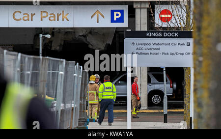 Les équipes de pompiers à plusieurs étages près de l'Echo Arena de Liverpool, après la nuit dernière, l'incendie qui a détruit des centaines de voitures. Banque D'Images