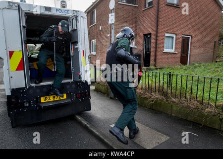 TSG (Groupe d'appui tactique) d'officiers bondir hors de la Land Rover PSNI pour entrer dans une propriété à Belfast, où l'interception d'envoi du cannabis a été destiné. La police a effectué une descente dans la propriété après un colis adressé à le bien a été saisi, il est apparu que la résidence a été récemment été libéré par le précédent occupant et un lien pour les locataires actuels a été écartée. Banque D'Images