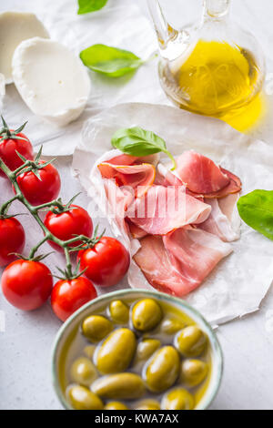 L'huile d'olive olives jambon tomates mozzarella au basilic - ingrédients italien ou une cuisine méditerranéenne. Banque D'Images