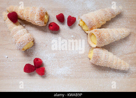 Feuilletés à la vanille et framboises cornes sur une planche en bois Banque D'Images