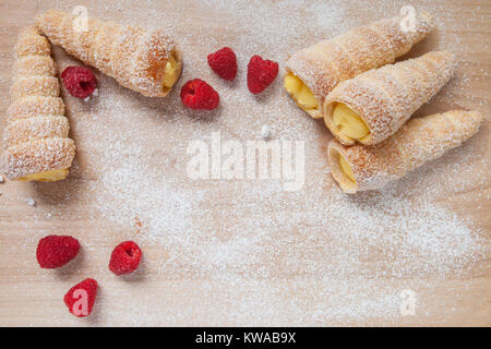 Feuilletés à la vanille et framboises cornes sur une planche en bois Banque D'Images