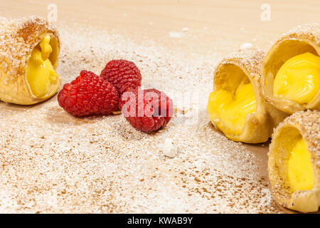 Feuilletés à la vanille et framboises cornes sur une planche en bois Banque D'Images