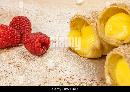 Feuilletés à la vanille et framboises cornes sur une planche en bois Banque D'Images