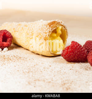 Feuilletés à la vanille et framboises cornes sur une planche en bois Banque D'Images