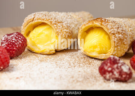 Feuilletés à la vanille et framboises cornes sur une planche en bois Banque D'Images