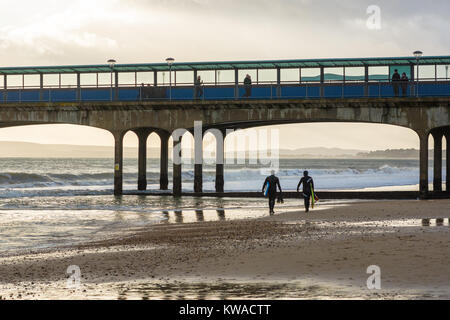 Boscombe Pier and Beach, Bournemouth, Dorset, Royaume-Uni. 1st janvier 2018. Jour de l'an. Les gens et surfeurs dehors pour une bouffée d'air frais d'hiver froid sur la plage et sur la jetée. Banque D'Images