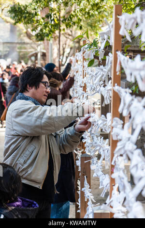 Le Japon, Nishinomiya culte. Nouvelle année. Au cours de l'homme Hatsumode, première visite de l'année à un temple, ses liens omikuji, fortune, d'un cadre de travail. Kyo. mauvaise fortune, les fiches sont laissés sur le lieu de culte. Banque D'Images