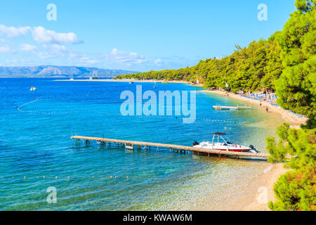 Bateau de tourisme à ancrage près de plage et jetée du cap célèbre plage de Zlatni Rat à Bol town, île de Brac, Croatie Banque D'Images