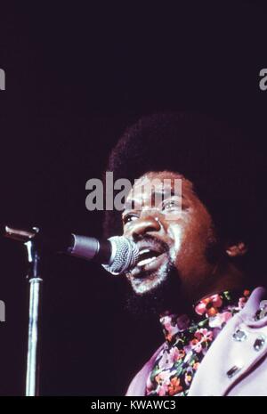 Au cours d'une expo annuelle Talent noir, un chanteur portant chemise et floral de la lavande sent le blazer clouté sur scène de chaleur, la transpiration du front sous sa haute taille Afro, chanter dans le micro d'un regard dans la foule, Chicago, Illinois, 1973. L'image de courtoisie des Archives nationales. Banque D'Images