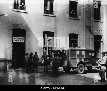 Un soldat américain blessé est pris d'une ambulance dans la pièce de réception d'un hôpital en France, 1944. La permission de la National Library of Medicine. Banque D'Images