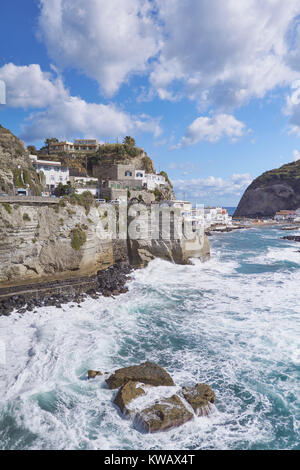 Célèbre village de Sant'Angelo Ischia avec falaises et les vagues se briser contre les rochers Banque D'Images