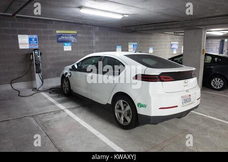 Volt de Chevrolet automobile électrique branché et de charge dans un parking couvert, avec un véhicule de l'air pur (CAV) Lecture de l'autocollant d'accord, l'accès de l'air pur le 3 octobre 2016. Les autocollants, qui permettent à un seul occupant d'un véhicule à rouler dans un covoiturage lane, sont délivrés aux conducteurs de véhicules électriques en Californie. Banque D'Images